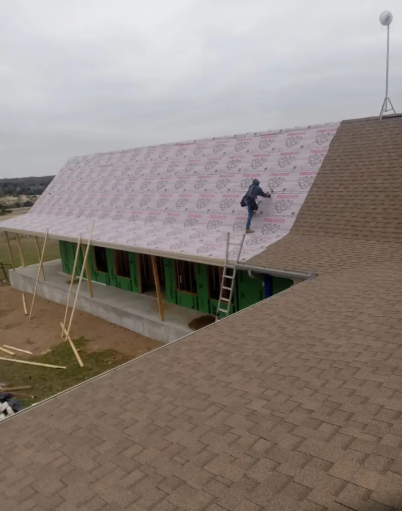 Worker preparing underlayment for a metal roof installation in Waterbury